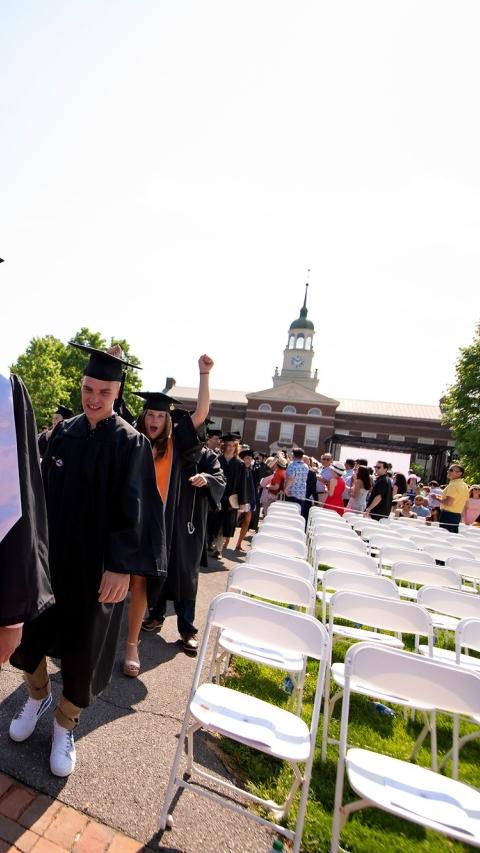 毕业生戴着学士帽和学士服进入毕业典礼